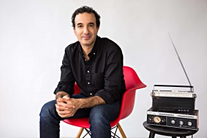 Jad Abumrad sits in a red chair next to an old-fashioned radio.