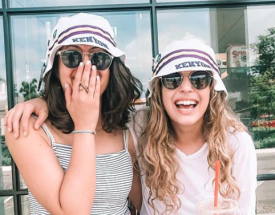 Two alumnae sport matching Kenyon hats.